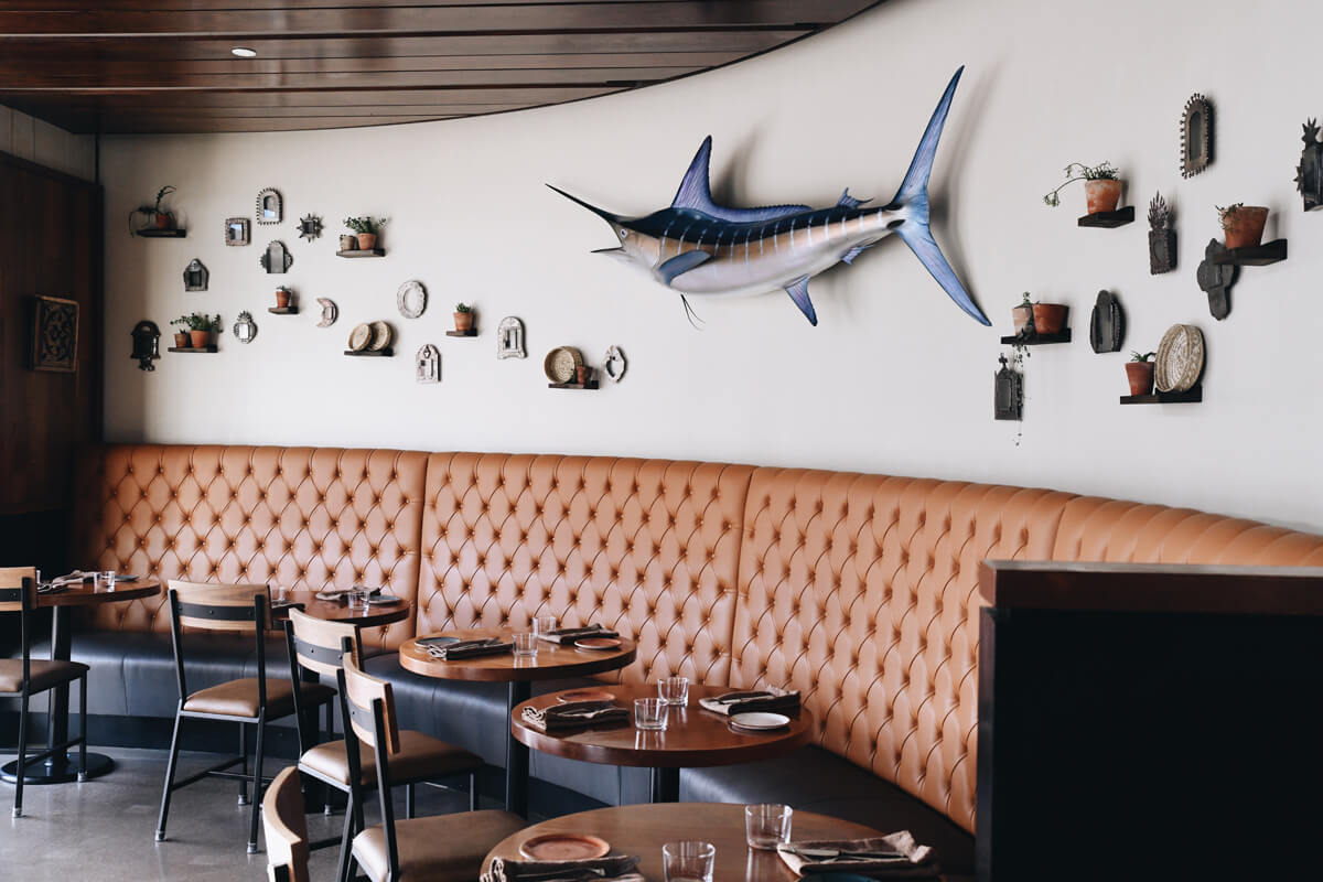 Modern dining room with tufted banquette and marlin wall art